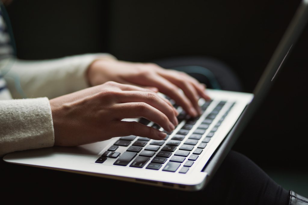 Woman's hands taping on a laptop